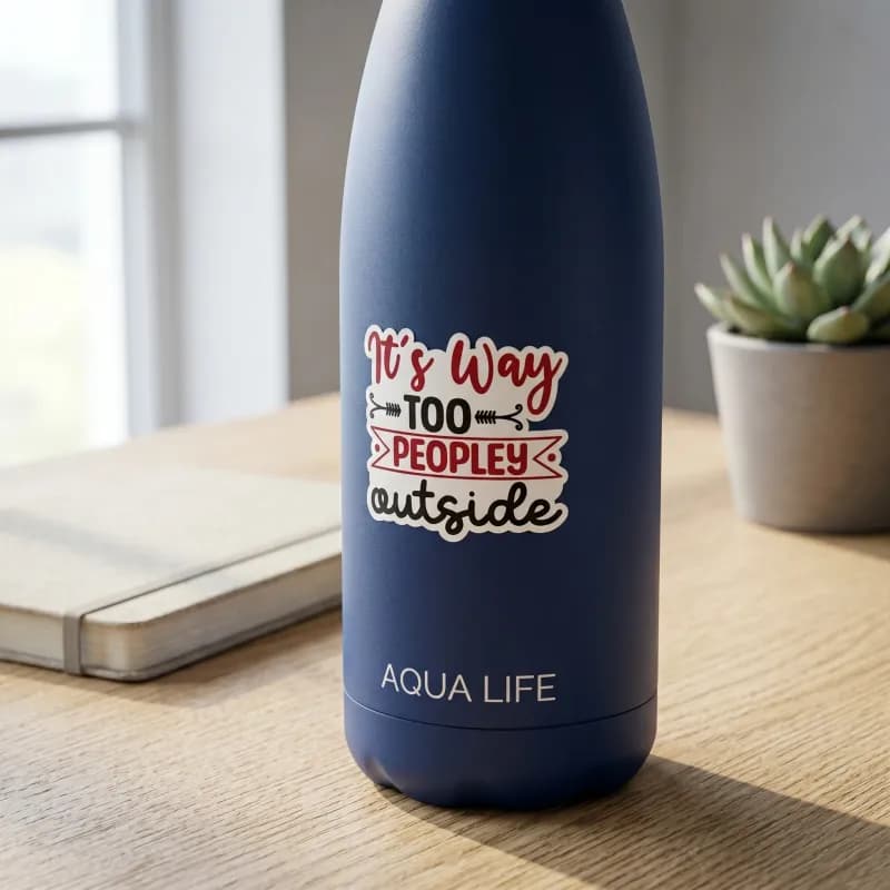 A blue water bottle with a sticker that reads "It's Way Too Peopley Outside" sits on a wooden surface next to a small potted plant and a closed notebook.